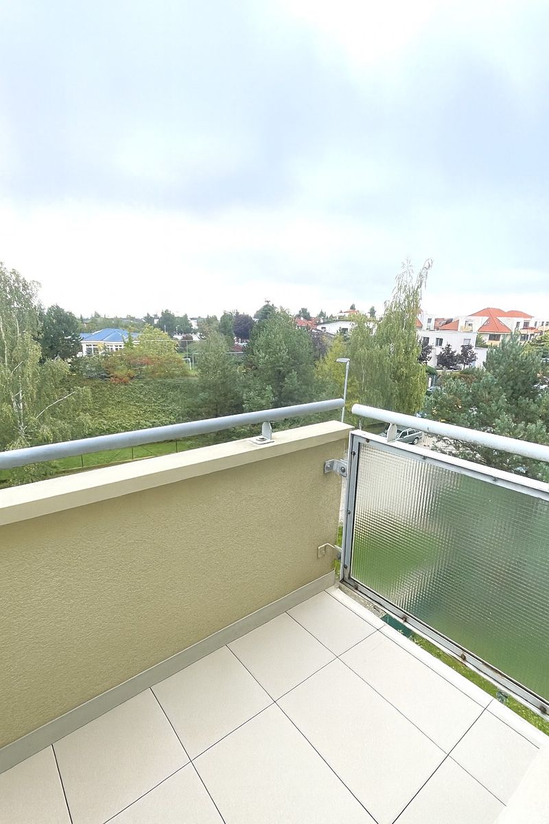 Výhled z balkonu přes zábradlí do zeleně