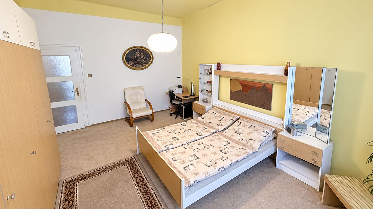 Ložnice s manželskou postelí a vysokými okny